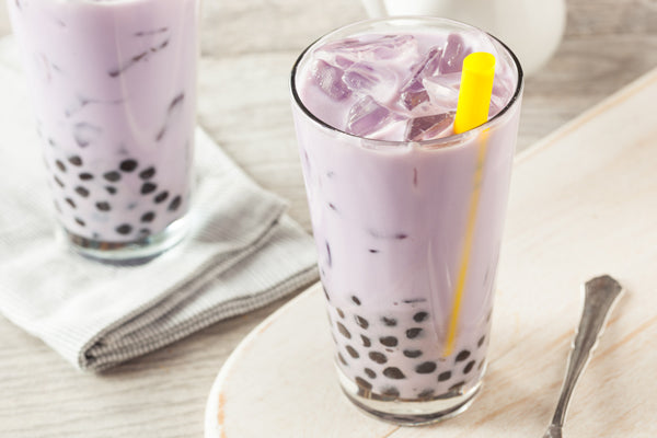 Taro Milk Tea with tapioca pearls placed on a counter
