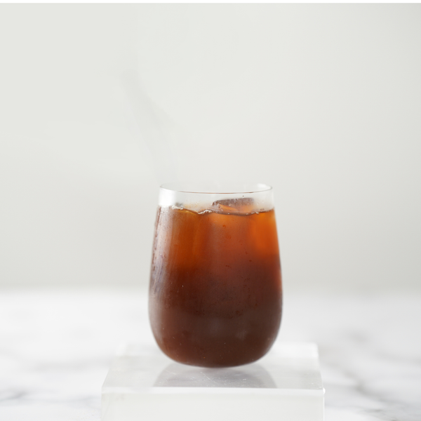 Glass of iced black tea on a white background view 4