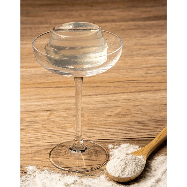 Plain jelly powder in a cocktail glass next to jelly powder sample and a spoon with a scoop of jelly powder view 3
